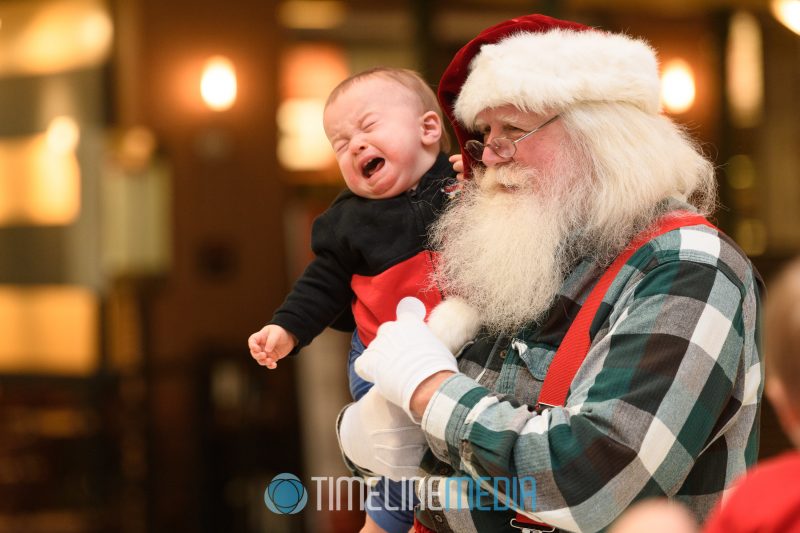 Toddler posing with Santa at an event in Tysons Corner Center
