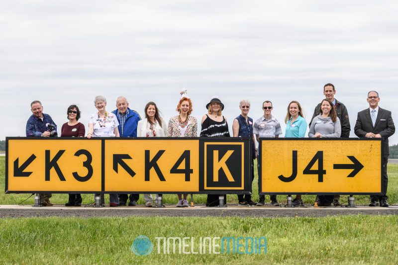 Birthday girl with family and friends at the runway signs at Dulles ©TimeLine Media